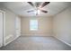 Clean and spacious bedroom with neutral carpet, ceiling fan, and ample natural light from a large window at 2091 Moon Drive Sw, Conyers, GA 30094
