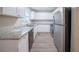 Modern kitchen featuring white cabinets, stainless steel appliances, granite countertops, and light grey flooring at 2091 Moon Drive Sw, Conyers, GA 30094