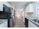 Modern kitchen with stainless steel appliances, granite countertops, light grey flooring, and open layout at 2091 Moon Drive Sw, Conyers, GA 30094