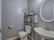 Powder room features toilet, sink, decorative shelving and gray walls at 2908 Cottesford Se Way, Smyrna, GA 30080