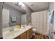 Bathroom featuring a double vanity, wood-look flooring, and a patterned shower curtain at 2908 Cottesford Se Way, Smyrna, GA 30080