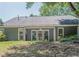 Home's back exterior shows a cozy patio, many windows, and large yard at 402 Roswell Green Ln, Roswell, GA 30075
