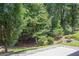 Spacious backyard featuring lush trees, greenery, and a concrete patio at 402 Roswell Green Ln, Roswell, GA 30075