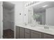 Bright bathroom features a double vanity with a large mirror, cabinets, and a nearby walk-in closet at 402 Roswell Green Ln, Roswell, GA 30075