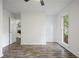 Empty bedroom with wood-look floors, one window, and view to another room with white fireplace at 402 Roswell Green Ln, Roswell, GA 30075