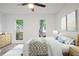 Bright bedroom features wood-look floors, a ceiling fan, and windows with views of the neighborhood at 402 Roswell Green Ln, Roswell, GA 30075