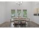 Dining room with an oval table and modern chandelier, with view to the backyard at 402 Roswell Green Ln, Roswell, GA 30075