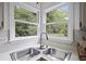 Kitchen sink with view of trees and landscaped backyard, and stainless steel fixtures at 402 Roswell Green Ln, Roswell, GA 30075