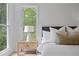 Bedroom detail with a lamp, bedside table, and large windows at 402 Roswell Green Ln, Roswell, GA 30075