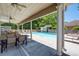 Outdoor pool area with covered seating, lounge chairs, and surrounding landscaping at 530 Mount Park Dr, Powder Springs, GA 30127