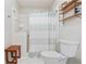 Bathroom with white tiled shower and a wooden bench; also includes a linen shelving unit at 1412 Oakridge Cir, Decatur, GA 30033
