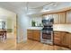 Well-lit kitchen with stainless steel appliances, wooden cabinets, and hardwood floors at 1412 Oakridge Cir, Decatur, GA 30033