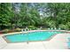Refreshing outdoor swimming pool with lounge chairs, surrounded by lush greenery and a secure fence at 1412 Oakridge Cir, Decatur, GA 30033