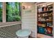 Cozy screened porch with outdoor seating, storage shelves, and a glimpse of the natural wooded scenery at 1412 Oakridge Cir, Decatur, GA 30033