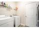 Laundry room with washer, dryer, storage shelf, and a door at 6418 Crown Forest Ct, Mableton, GA 30126