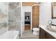 Bright bathroom showcasing a vessel sink, marble tile in the shower, and a view to the bedroom at 87 Peachtree Sw St # 209, Atlanta, GA 30303