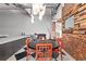 Dining area with round table and chairs beside an exposed brick wall and modern lighting fixture at 87 Peachtree Sw St # 209, Atlanta, GA 30303