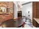 Dining area with a round dark wood table and colorful chairs, next to a decorative brick wall at 87 Peachtree Sw St # 209, Atlanta, GA 30303