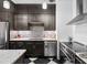 Stylish kitchen featuring stainless steel appliances, dark cabinetry, a tile backsplash, and an island at 87 Peachtree Sw St # 209, Atlanta, GA 30303