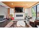 Bright living room has a modern fireplace beneath a flatscreen TV, wood ceiling and exposed brick at 87 Peachtree Sw St # 209, Atlanta, GA 30303