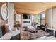 Bright living room features wood ceiling, exposed brick, and a modern fireplace beneath a flatscreen TV at 87 Peachtree Sw St # 209, Atlanta, GA 30303
