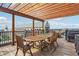 Inviting rooftop deck with pergola, string lights, and a large wooden dining table, offering city views at 87 Peachtree Sw St # 209, Atlanta, GA 30303