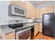 Efficient kitchen design with stainless steel appliances, wood cabinets, and modern fixtures at , Atlanta, GA 30306