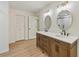 Bright bathroom featuring a double vanity with modern fixtures and oval mirrors at 145 Devilla Trce, Fayetteville, GA 30214