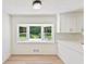 Cozy breakfast nook with a bay window overlooking the green yard, white cabinets, and herringbone backsplash at 145 Devilla Trce, Fayetteville, GA 30214