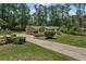 Sprawling ranch-style home showcasing an attached garage and a long driveway surrounded by mature trees at 145 Devilla Trce, Fayetteville, GA 30214