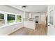 Bright kitchen featuring white cabinets, stainless steel appliances, a herringbone backsplash, and wood-look floors at 145 Devilla Trce, Fayetteville, GA 30214