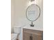 Modern powder room featuring a round mirror, black faucet, and light wood vanity at 145 Devilla Trce, Fayetteville, GA 30214