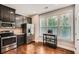 Well-lit kitchen with stainless steel appliances, dark cabinets, hardwood floors, and bright natural light at 2300 Whiteoak Drive Southeast Se Dr, Smyrna, GA 30080