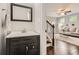 Stylish powder room with a dark vanity, modern sink, and decorative mirror adjacent to the staircase at 2300 Whiteoak Drive Southeast Se Dr, Smyrna, GA 30080
