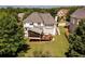 Expansive backyard featuring a deck, screened porch, lush lawn, and mature trees, perfect for outdoor living at 2484 Mossy Branch Dr, Snellville, GA 30078