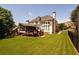Spacious backyard with well-maintained lawn, mature trees, a screened porch, and a deck, perfect for outdoor activities at 2484 Mossy Branch Dr, Snellville, GA 30078
