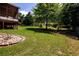 Beautiful landscaped backyard featuring green lawn, a variety of trees, and a screened porch, ideal for outdoor living at 2484 Mossy Branch Dr, Snellville, GA 30078