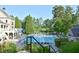 Large community pool is surrounded by lush landscaping, lounge chairs and mature shade trees at 2484 Mossy Branch Dr, Snellville, GA 30078