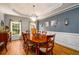 Formal dining room with a chandelier, wainscoting, and large windows offering ample natural light at 2484 Mossy Branch Dr, Snellville, GA 30078