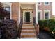 Brick home entryway featuring a black front door, brick steps, and wrought iron railings at 2484 Mossy Branch Dr, Snellville, GA 30078