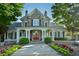Charming two-story home with stone accents, a red door, and a beautifully landscaped front yard at 2484 Mossy Branch Dr, Snellville, GA 30078