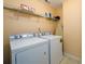 Practical laundry room with white washer and dryer, storage shelf, and ironing board at 2484 Mossy Branch Dr, Snellville, GA 30078