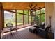 Enclosed porch with wood ceiling features walls of windows and comfortable seating for enjoying outdoor views at 2484 Mossy Branch Dr, Snellville, GA 30078