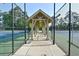 Covered walkway between two well-maintained tennis courts in a beautiful setting at 2484 Mossy Branch Dr, Snellville, GA 30078