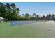Well-maintained tennis court with blue and green surface and shaded seating area at 2484 Mossy Branch Dr, Snellville, GA 30078