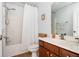 Well-lit bathroom with white shower curtain, wood vanity, framed art, and tile flooring at 3537 Edenridge Ct, Buford, GA 30519