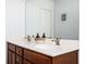 Bathroom with dual sinks, dark cabinets, and a large mirror reflecting the door at 3537 Edenridge Ct, Buford, GA 30519