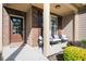 Inviting covered front porch with seating area, a welcome mat and brick accents at 3537 Edenridge Ct, Buford, GA 30519