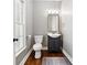 Cozy powder room featuring a hardwood floor, floating vanity, and framed mirror at 5060 Winship Ct, Alpharetta, GA 30009
