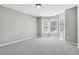 A bedroom with neutral gray walls and carpeting featuring a bay window with blinds at 5060 Winship Ct, Alpharetta, GA 30009